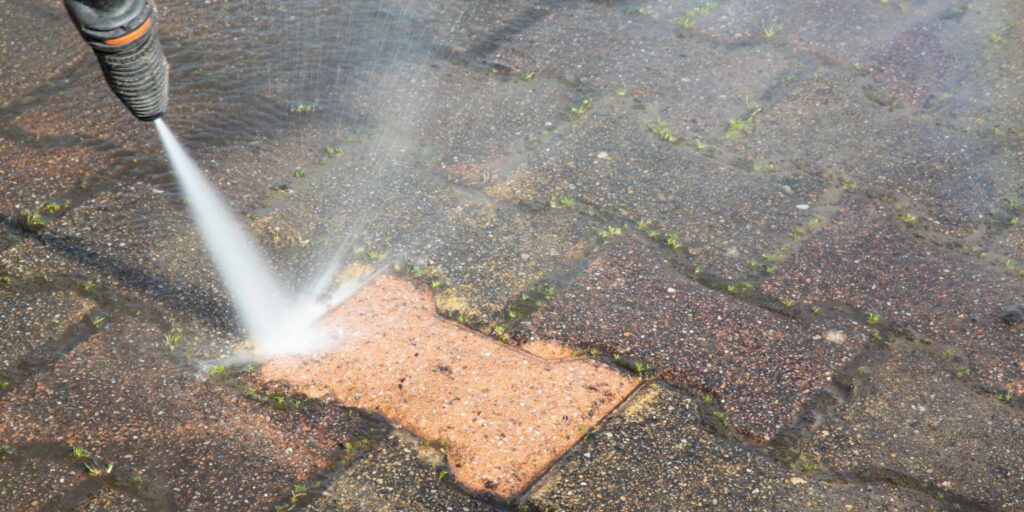 Pressuring washing residue off of brick driveway